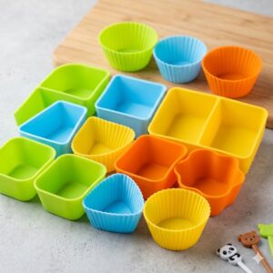 A variety of flexible silicone bento box dividers in different shapes and bright colors for customized meal planning.